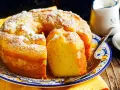 Gâteau sans gluten, saupoudré de sucre glace, sur une assiette décorée. Une part est coupée, prête à être dégustée.