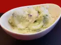 Salade fraîche de concombre à la crème, parsemée d'herbes fines. Un délice léger et savoureux.