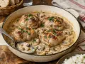 Quatre paupiettes de veau dorées, nappées d'une sauce crémeuse aux champignons, prêtes pour la cuisson.