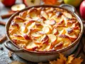 Un délicieux flan aux pommes, doré et saupoudré de sucre glace, prêt à être dégusté. Des pommes fraîches et des bâtons de cannelle l'entourent.