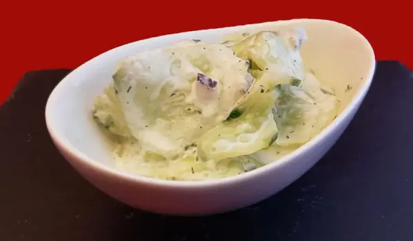 Salade fraîche de concombre à la crème, parsemée d'herbes fines. Un délice léger et savoureux.